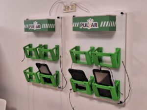 Zidni nosač za tablet i punjač, minimalističkog i funkcionalnog dizajna, izrađen za sigurno držanje uređaja i organizirano punjenje, montiran na uredni zidni prostor.